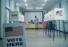Interior of a polling station with voting booths and officials