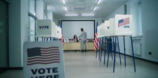 Interior of a polling station with voting booths and officials