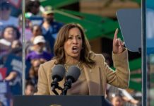 A woman passionately delivering a speech at a rally