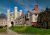 Gothic stone university building with clock tower and archway