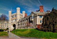 Gothic stone university building with clock tower and archway