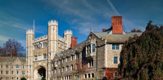 Gothic stone university building with clock tower and archway