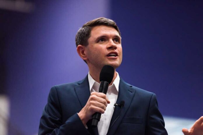Austin,,Texas,United,States,-,July,25th,,2025,-,James A man in a suit speaking into a microphone at a conference