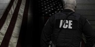 ICE agent standing in front of an American flag