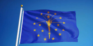 Indiana state flag waving against a blue sky