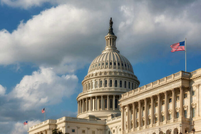shutterstock1896126403-1jpg The U.S. Capitol building with a dome and an American flag under a cloudy sky