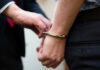 Warnings Ignored—Hawaii Bloodbath Follows A close-up of a person being handcuffed by an officer
