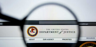 Close-up view of the Department of Justice website through a magnifying glass