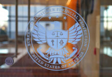 Insider Tapped To Tame Watchdog Glass door with U.S. federal agency seal