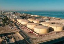 Fragile Ceasefire Teases Cheaper Gas Aerial view of large oil storage tanks near a coastal area