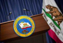 Late Ballots Scramble Sacramento Podium with the seal of the Governor of California and state flag in the background