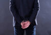 Jury Exposes Chilling Cop Cover-Up A man in a suit with hands cuffed behind his back