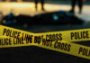 Dream Home Purchase Turns Into Nightmare Yellow police caution tape at a crime scene with blurred figures in the background