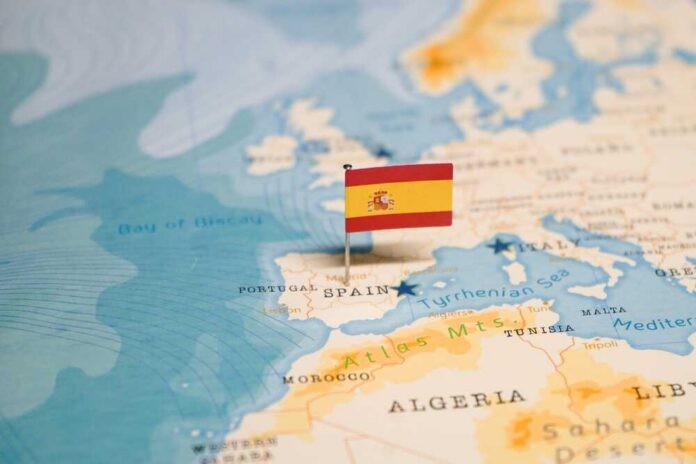 The,Flag,Of,Spain,On,The,World,Map. Map highlighting Spain with a small flag