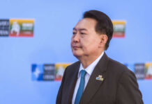 30-Year Shock: Ex-President’s ‘Fake War’ Plot A political leader in formal attire at a conference with a serious expression