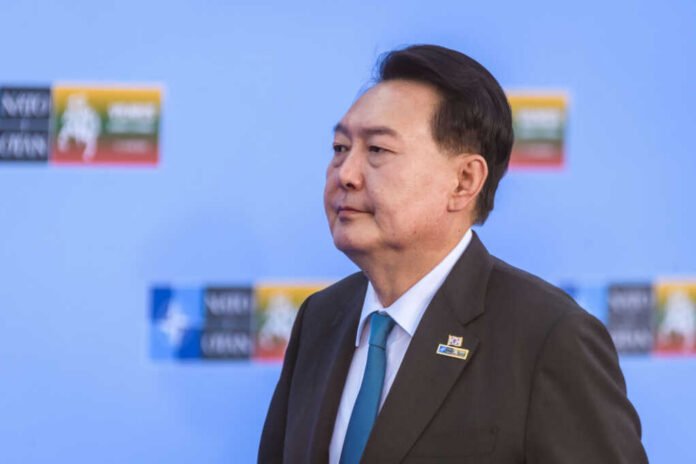 A political leader in formal attire at a conference with a serious expression
