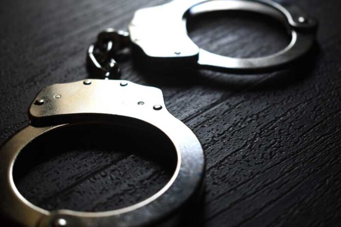 Close-up of metallic handcuffs on a textured surface