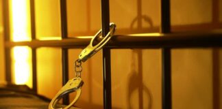 Close-up of handcuffs attached to a bed frame
