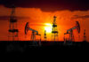 Nuclear Comeback—or Local Families on the Hook? Silhouetted oil rigs against a vibrant sunset