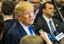 Weapons Production Set To Quadruple A man speaking to reporters at a press event surrounded by media personnel