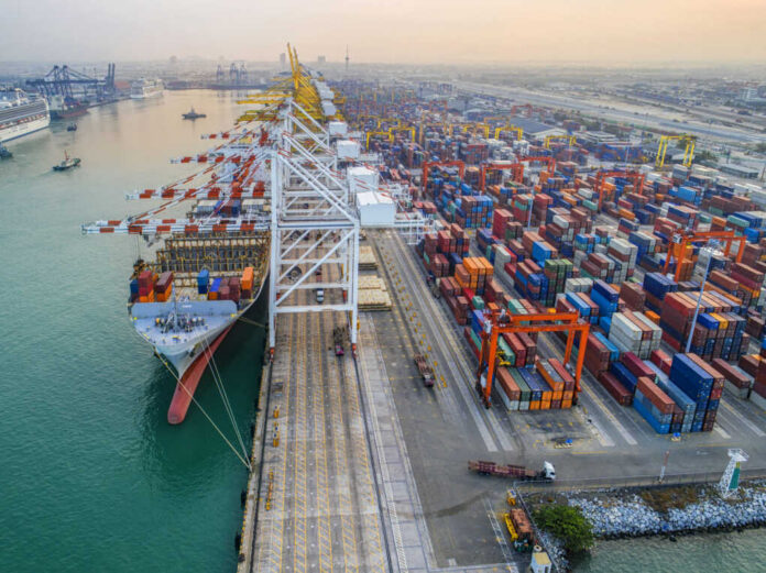 Aerial view of a busy shipping port with cargo containers and a large ship