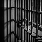 Close-up of prison bars casting shadows on a wall