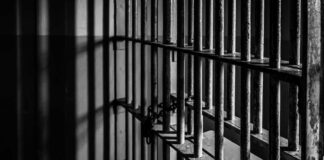 Close-up of prison bars casting shadows on a wall