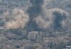 Iran Reports Troops Killed In Strikes Smoke rising from a city in a mountainous area