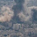 Smoke rising from a city in a mountainous area