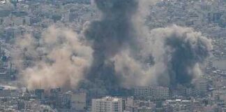 Smoke rising from a city in a mountainous area