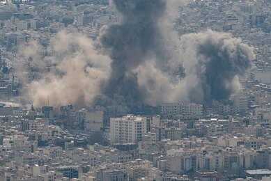 Smoke rising from a city in a mountainous area