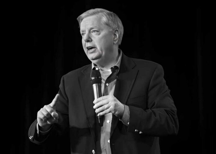 Man in a suit speaking into a handheld microphone