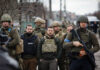 A group of military personnel in tactical gear walking through an urban area