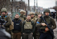 Trump Holds Ukraine Peace Calls A group of military personnel in tactical gear walking through an urban area