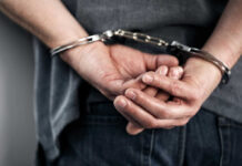 Hands cuffed behind the back, indicating arrest
