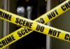 Probe Widens After Epstein Ally Found Dead Yellow crime scene tape crossing a doorway