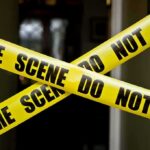 Yellow crime scene tape crossing a doorway