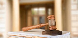 judge's gavel resting on a stack of case files