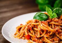 Pasta Promo Outranks Elections? Spaghetti bolognese topped with basil on a white plate