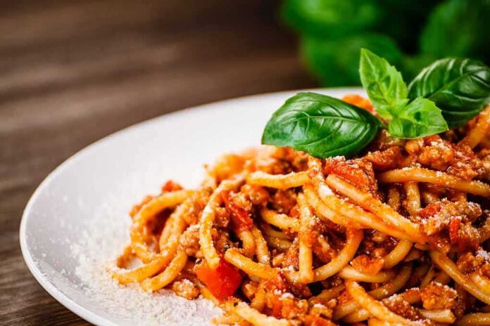 shutterstock_1084624817 Spaghetti bolognese topped with basil on a white plate