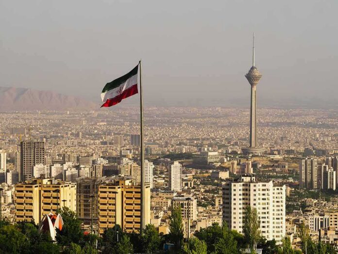 Iranian flag over Tehran skyline with Milad Tower