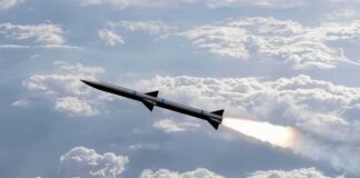 Rocket flying above clouds with bright exhaust plume