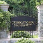 ornate campus entrance sign on wrought iron gate