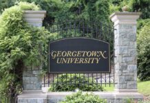 ornate campus entrance sign on wrought iron gate