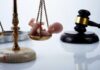 Officer Convicted In Unborn Child Killing Scales of justice with a baby figurine and a gavel in the background