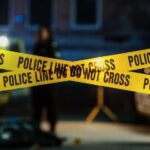 A Backyard Tragedy Every Parent Fears Police tape marking a crime scene with blurred figures in the background