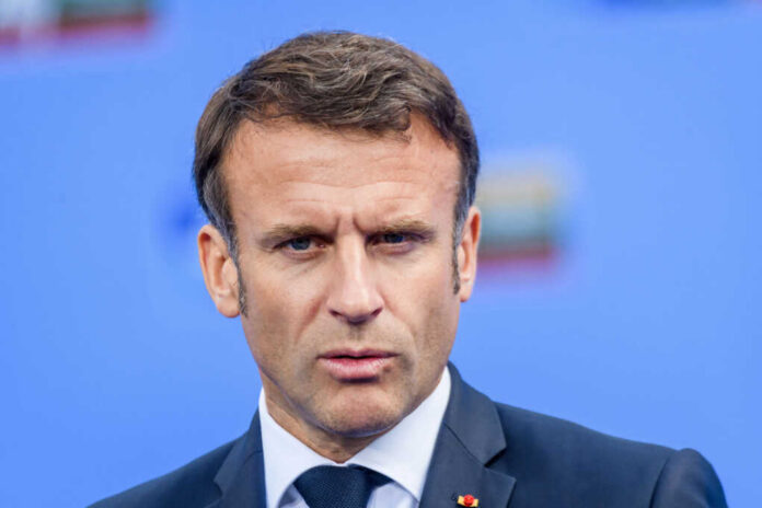 shutterstock_2409931523 Close-up portrait of a serious-looking male political leader in formal attire against a blue background