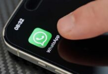 Finger tapping the WhatsApp icon on a smartphone screen