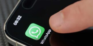 Finger tapping the WhatsApp icon on a smartphone screen