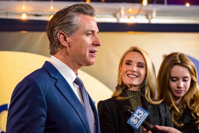 Sacramento,,Ca,,U.s.a.,-,Feb.,6,,2024:,Governor,Gavin,Newsom Man in suit speaking at a podium with American and California flags